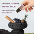 Hand dripping LAIFU Gentlemen's essential oil onto a lava rock diffuser with cinnamon stick and pine cone, highlighting long-lasting natural fragrance.