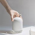 Close-up of a hand holding the cute deer white humidifier, showcasing the smooth white body and rose gold antler design.