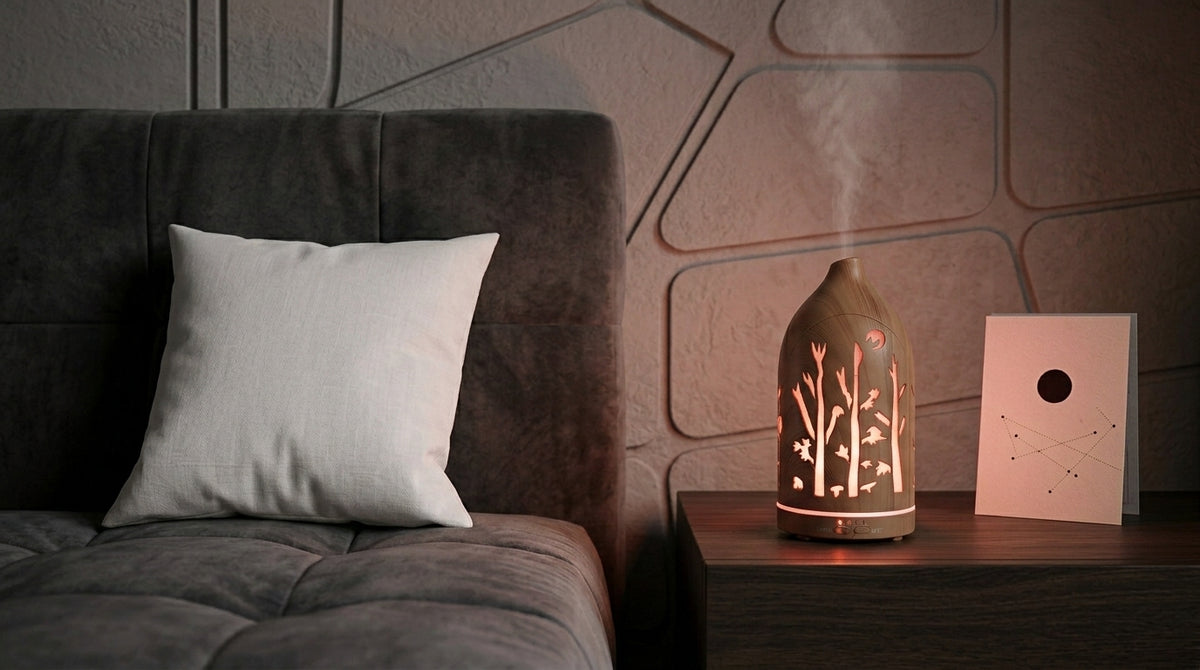 Light wood grain forest cutout diffuser emitting a cool red LED light on a dark wooden nightstand in a modern bedroom with geometric wall panels and a constellation card.