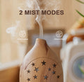 Close-up of the light wood star diffuser demonstrating 2 mist modes: Continuous and Intermitten (Intermittent) operation.