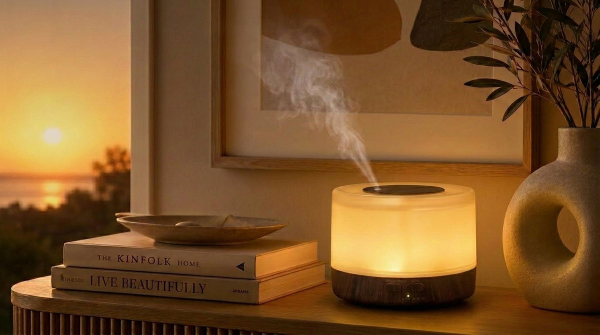 Pniaw round dark wood diffuser glowing with warm yellow light on a console table at sunset, styled with books and modern ceramic vase.