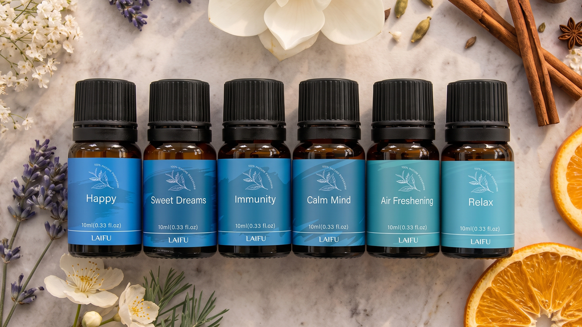 Full lineup of the 6-blend essential oil set (Happy, Sweet Dreams, Immunity, Calm Mind, Air Freshening, Relax) on a marble surface with cinnamon sticks and orange slices.