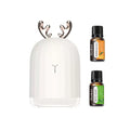 Cute deer white humidifier with rose gold antlers bundled with an essential oil set including Orange and Mint Leaf oils on a white background.