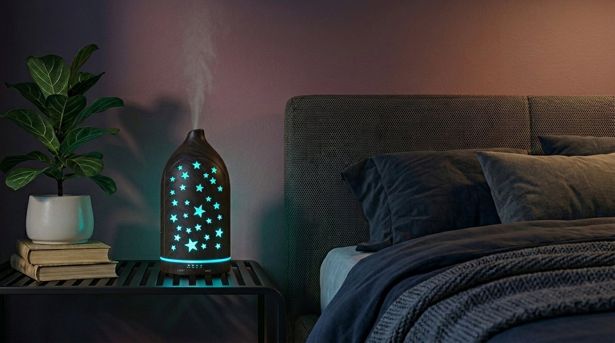 Dark wood grain star cutout diffuser emitting a calming light blue starlight glow on a modern nightstand in a dimly lit bedroom, next to a fiddle leaf fig plant.