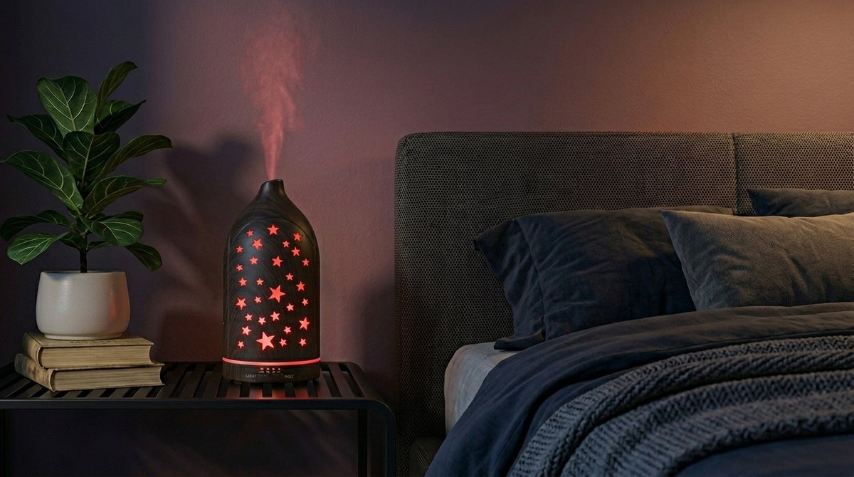 Dark wood grain star cutout diffuser emitting a calming red starlight glow on a modern nightstand in a dimly lit bedroom, next to a fiddle leaf fig plant.