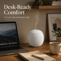 Desk-ready comfort with the mini lantern diffuser on a wooden desk next to a laptop and notebook, providing focus by day and unwinding by night.
