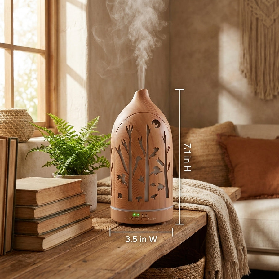 Light wood forest aromatherapy diffuser with dimensions labeled (7.1 inches height, 3.5 inches width) on a rustic bench with books and a fern plant.
