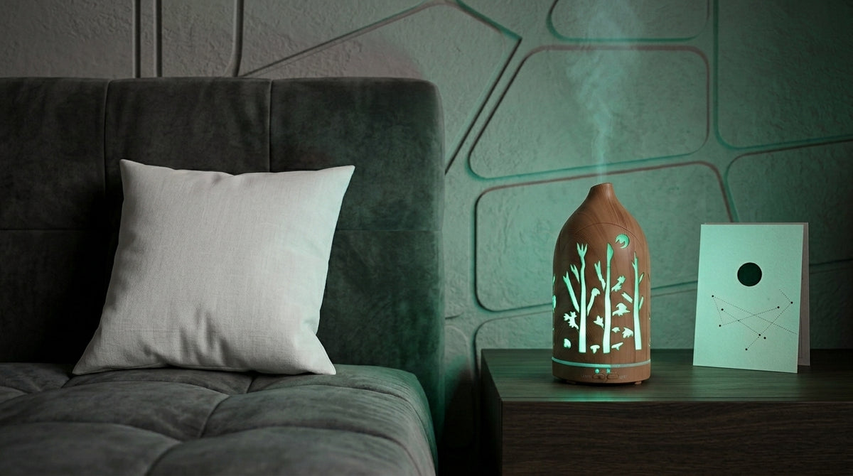 Light wood grain forest cutout diffuser emitting a cool green LED light on a dark wooden nightstand in a modern bedroom with geometric wall panels and a constellation card.