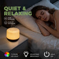 Pniaw 500ml diffuser operating at 22dB noiselessness on a nightstand next to a sleeping woman, featuring 7-color LED light with adjustable brightness.