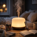 Pniaw 500ml wood grain diffuser glowing with warm LED night light on a cozy bedroom nightstand, accompanied by a remote control and essential oil set.