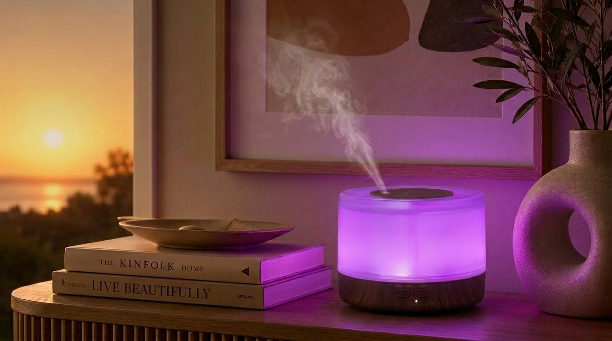 Pniaw round dark wood diffuser glowing with purple light on a console table at sunset, styled with books and modern ceramic vase.