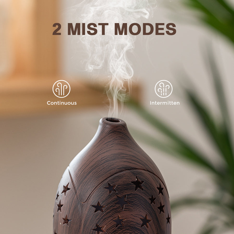 Close-up of the dark wood star diffuser demonstrating 2 mist modes: Continuous and Intermitten (Intermittent) for customized aroma intensity.
