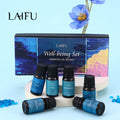 Well-being essential oil blends gift set displayed on a white pedestal with a blue flower decoration, perfect for gifting.